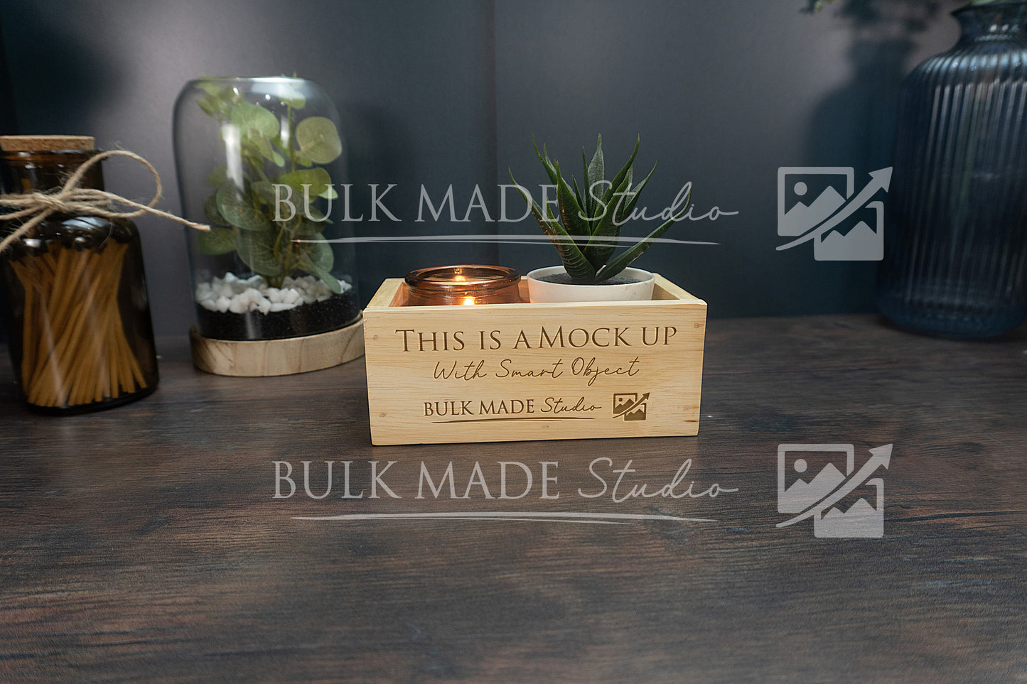 Wooden box with a candle and plant on a dark surface, branded 'Bulk Made Studio'.