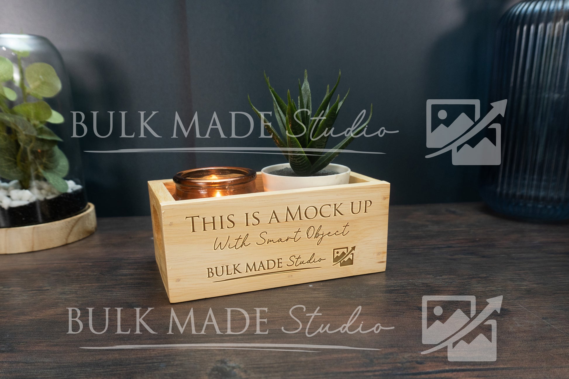 Wooden box with plant and candle on a dark surface, branded 'Bulk Made Studio'.